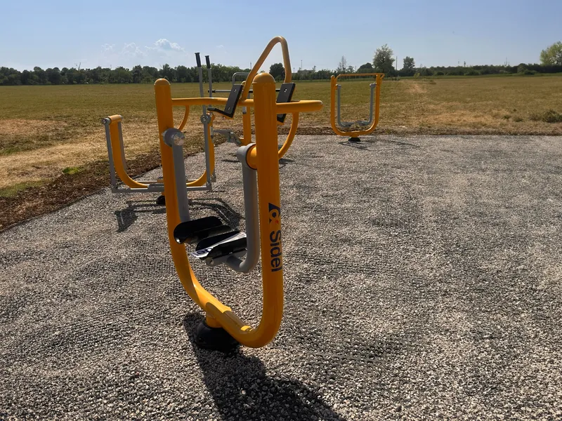 Macchine fitness outdoor a carico naturale installate presso l'azienda Sidel per attività fisica all'aria aperta e benessere dei dipendenti.