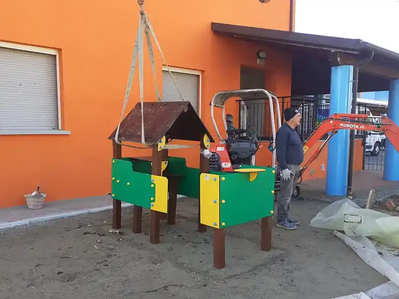 Pavimentazione in gomma colata per la Scuola Materna di Tizzano Val Parma: più sicurezza per l’area gioco 158 Fase finale di installazione della casetta gioco in plastica riciclata nella scuola materna di Tizzano Val Parma
