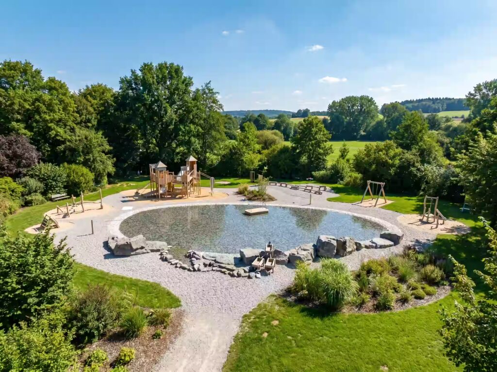 Materiali Naturali per Pavimentazioni di Parchi Giochi: Sicurezza, Sostenibilità e Integrazione con l'Ambiente 208 Area outdoor a Ravascletto vista dall’alto con percorsi, spazi relax e inserimento nel paesaggio verde